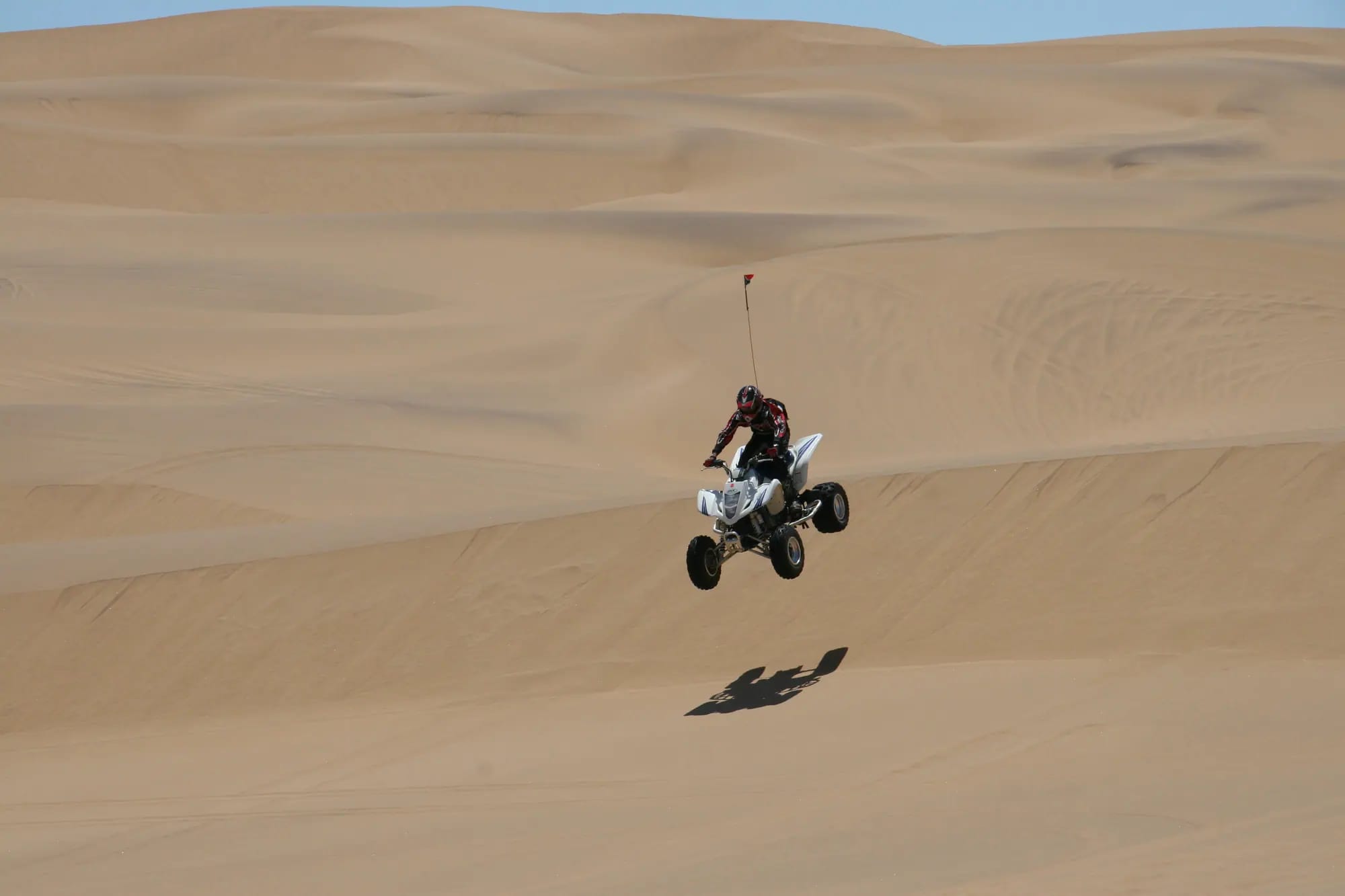 Quad bike jumping a dune in the Qatar desert