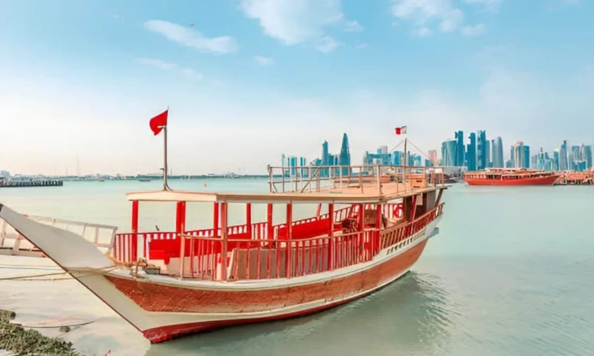 Red dhow on Doha Bay with the city skyline